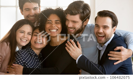 Overjoyed multiracial colleagues hug showing unity and support 106482075