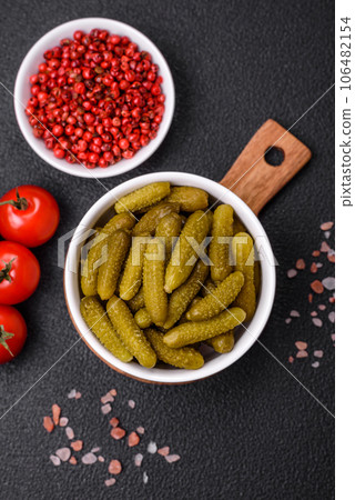 Delicious small pickled cucumbers gherkins with onions, mustard, salt and spices Delicious small pickled cucumbers gherkins with onions, mustard, salt and spices 106482154