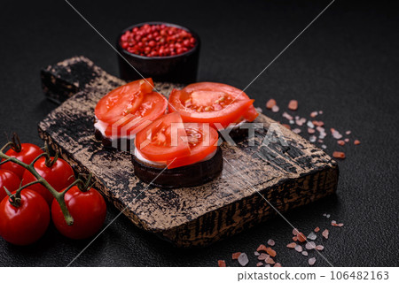 Delicious eggplant cut into circles grilled and cooked with mayonnaise and tomatoes 106482163