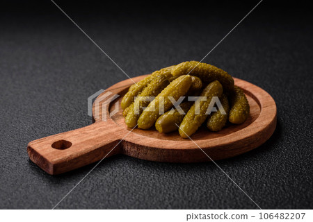 Delicious small pickled cucumbers gherkins with onions, mustard, salt and spices 106482207