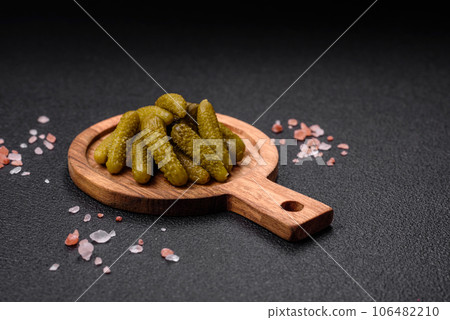Delicious small pickled cucumbers gherkins with onions, mustard, salt and spices 106482210