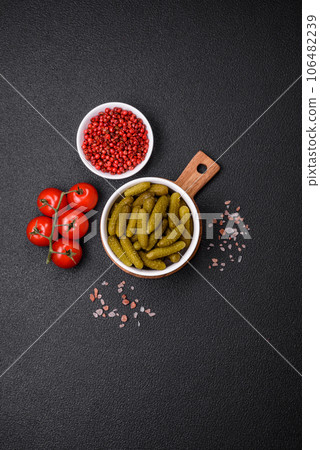 Delicious small pickled cucumbers gherkins with onions, mustard, salt and spices Delicious small pickled cucumbers gherkins with onions, mustard, salt and spices 106482239