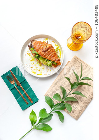 Croissant with cheese and vegetables in white plate. Top view on white table 106483489