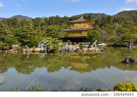 Kyoto in spring in Japan, Kinkaku-ji Temple, a world heritage site, the golden Shariden, beautiful blue sky and Rokuon-ji Garden, a large bird perched on the rock Kyoto in spring in Japan, Kinkaku-ji Temple, a world heritage site, the golden Shariden, beautiful blue sky and Rokuon-ji Garden, a large bird perched on the rock 106484893
