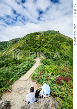 A couple taking a break on the mountain trail of Mt. Tanigawadake A couple taking a break on the mountain trail of Mt. Tanigawadake 106488147