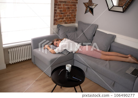 young beautiful woman lies on the sofa in the living room in the apartment 106490277