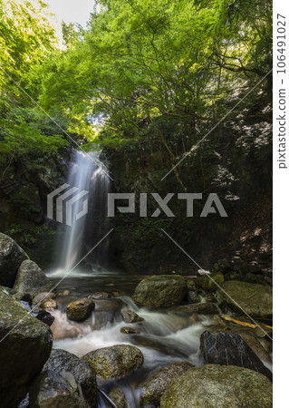 A waterfall in the valley that shines in the fresh greenery A waterfall in the valley that shines in the fresh greenery 106491027