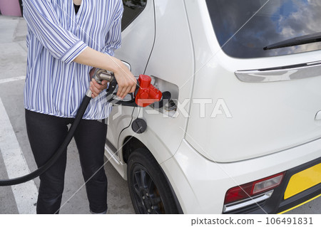Man refueling car at petrol station 106491831