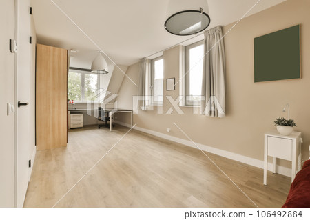 a living room with wood flooring and white trim on the walls, there is a red couch in front a living room with wood flooring and white trim on the walls, there is a red couch in front 106492884