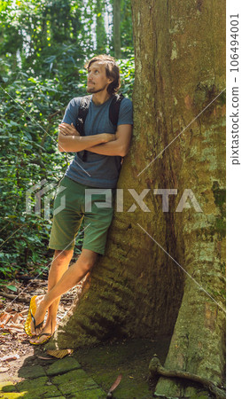 A man near a huge tree. The roots of an old tree, bali. Travel destination of Bali island, culture, art objects, of Indonesian people VERTICAL FORMAT for Instagram mobile story or stories size. Mobile 106494001