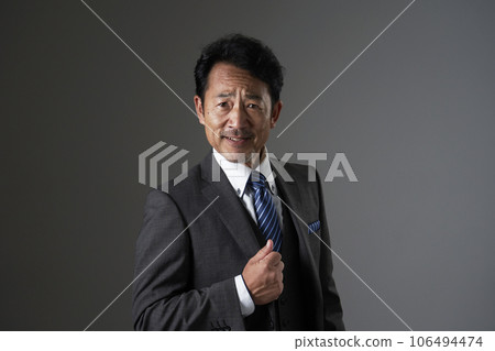 一位中年商人的肖像，黑色背景，看著相機 106494474