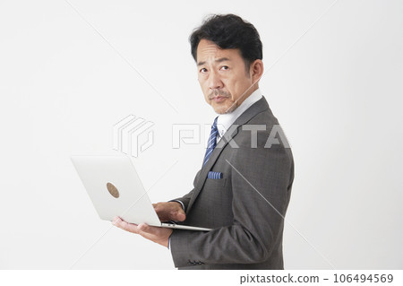 使用筆記本電腦白色背景的中年商人 106494569