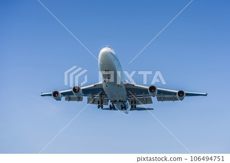 A white airplane flying in a clear pale blue sky A white airplane flying in a clear pale blue sky 106494751