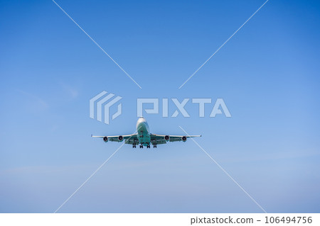 A white airplane flying in a clear pale blue sky A white airplane flying in a clear pale blue sky 106494756