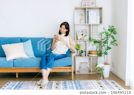 年輕女子在客廳裡放鬆，智能手機 106495218