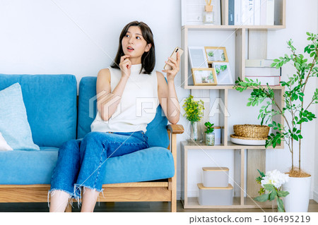 年輕女子在客廳裡放鬆，智能手機 106495219