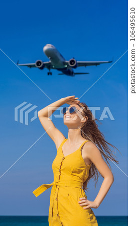 Woman have fun on the beach watching the landing planes. Traveling on an airplane concept. Text space. Island Phuket in Thailand. Impressive paradise. Hot beach Mai Khao. Amazing landscape VERTICAL Woman have fun on the beach watching the landing planes. Traveling on an airplane concept. Text space. Island Phuket in Thailand. Impressive paradise. Hot beach Mai Khao. Amazing landscape VERTICAL 106495610