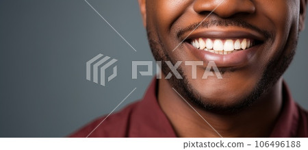 Happily smiling African American young man with perfectly white even teeth. Smiling mouth close up. Happily smiling African American young man with perfectly white even teeth. Smiling mouth close up. 106496188