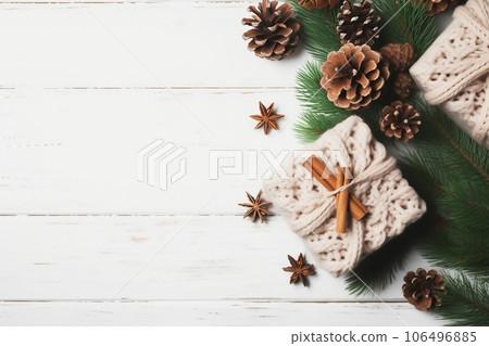 Christmas composition. Christmas gift, knitted blanket, pine cones, fir branches on wooden white background. Flat lay, top view, copy space 106496885