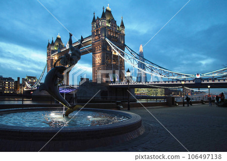 Dolphin fountain and Tower bridge in London at dusk 106497138