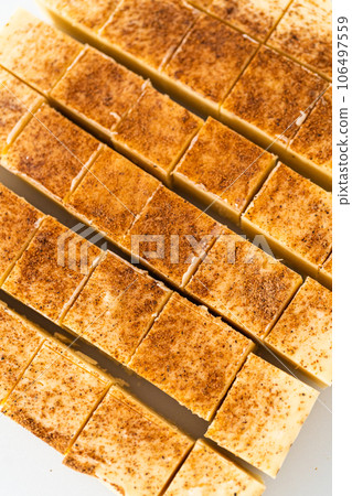 Homemade eggnog fudge pieces on a white cutting board. 106497559