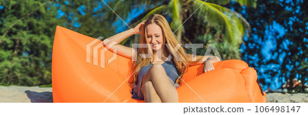 Summer lifestyle portrait of pretty girl sitting on the orange inflatable sofa on the beach of tropical island. Relaxing and enjoying life on air bed BANNER, LONG FORMAT Summer lifestyle portrait of pretty girl sitting on the orange inflatable sofa on the beach of tropical island. Relaxing and enjoying life on air bed BANNER, LONG FORMAT 106498147