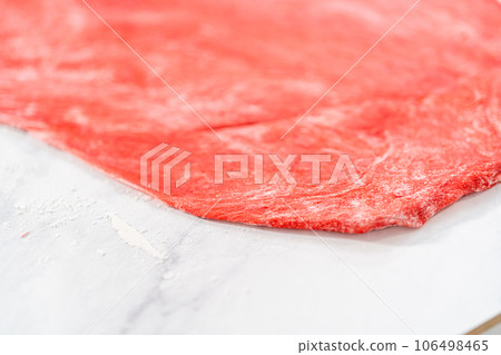 Rolling red and blue bread dough to bake patriotic cinnamon twists. Rolling red and blue bread dough to bake patriotic cinnamon twists. 106498465