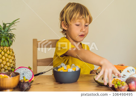 Boy eats fruit. Healthy food for children. Child eating healthy snack. Vegetarian nutrition for kids. Vitamins for children Boy eats fruit. Healthy food for children. Child eating healthy snack. Vegetarian nutrition for kids. Vitamins for children 106498495