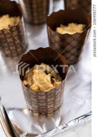 Rising dough in paper liners to bake mini Easter bread kulich. Rising dough in paper liners to bake mini Easter bread kulich. 106498777