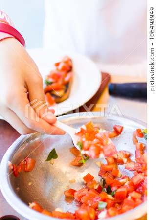 Kinds in cooking class making bruschetta. Kinds in cooking class making bruschetta. 106498949