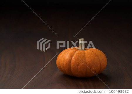 Small pumpkin on wood table with copy space background 106498982