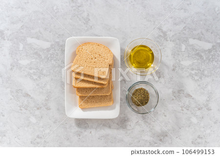 Flat lay. Measured ingredients in glass mixing bowls to make croutons. Flat lay. Measured ingredients in glass mixing bowls to make croutons. 106499153