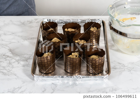 Rising dough in paper liners to bake mini Easter bread kulich. Rising dough in paper liners to bake mini Easter bread kulich. 106499611
