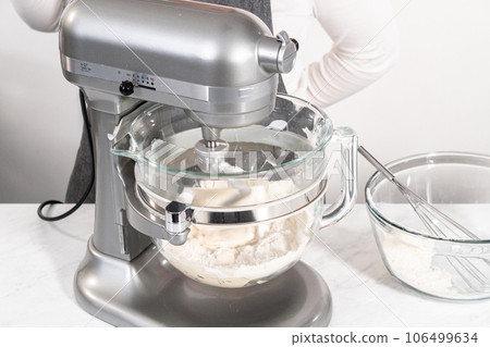 Mixing bread dough in a stand-alone kitchen mixer to bake patriotic cinnamon twists. 106499634