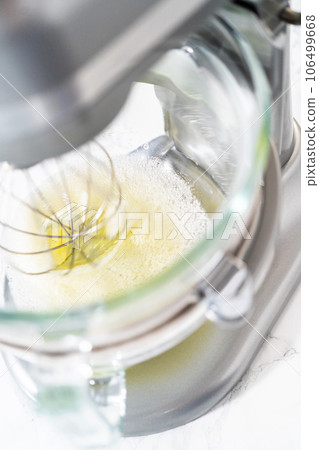 Whipping egg whites in a stand electric mixer to bake meringue cookies. 106499668
