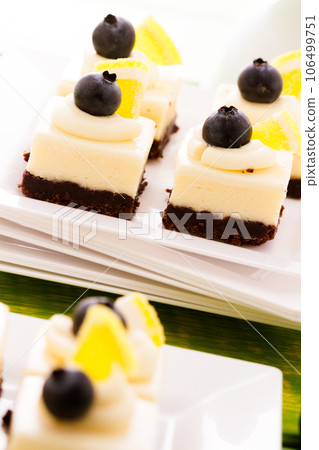 Small white chocolate cheesecake squares at dessert bar. 106499751