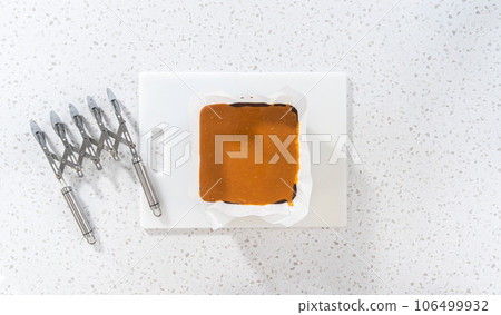 Flat lay. Scoring caramel fudge using a wheel dough cutter for cutting into small square pieces. Flat lay. Scoring caramel fudge using a wheel dough cutter for cutting into small square pieces. 106499932
