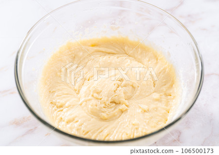 Mixing ingredients in a large glass mixing bowl to bake apple bundt cake with caramel glaze. Mixing ingredients in a large glass mixing bowl to bake apple bundt cake with caramel glaze. 106500173
