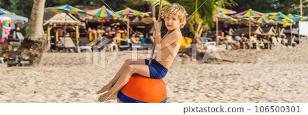A boy on a swing on the beach. Mom and son spend time on the beach BANNER, LONG FORMAT 106500301