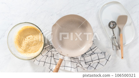 Flat lay. Preparing eggnog pancakes in a nonstick frying pan. 106500321