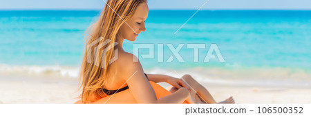 Summer lifestyle portrait of pretty girl sitting on the orange inflatable sofa on the beach of tropical island. Relaxing and enjoying life on air bed BANNER, LONG FORMAT 106500352