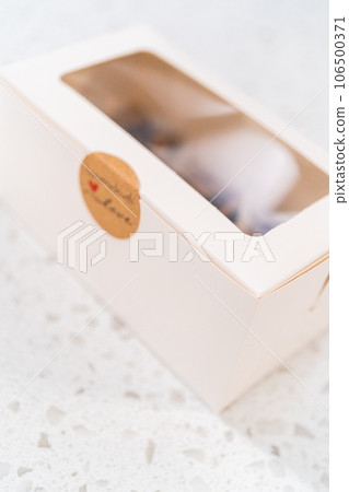 Packaging homemade chocolate fudge with peanut butter swirl into a white gift box. 106500371