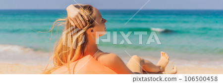 Summer lifestyle portrait of pretty girl sitting on the orange inflatable sofa on the beach of tropical island. Relaxing and enjoying life on air bed BANNER, LONG FORMAT Summer lifestyle portrait of pretty girl sitting on the orange inflatable sofa on the beach of tropical island. Relaxing and enjoying life on air bed BANNER, LONG FORMAT 106500458