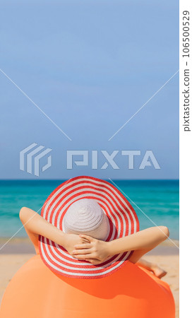 Summer lifestyle portrait of pretty girl sitting on the orange inflatable sofa on the beach of tropical island. Relaxing and enjoying life on air bed VERTICAL FORMAT for Instagram mobile story or Summer lifestyle portrait of pretty girl sitting on the orange inflatable sofa on the beach of tropical island. Relaxing and enjoying life on air bed VERTICAL FORMAT for Instagram mobile story or 106500529