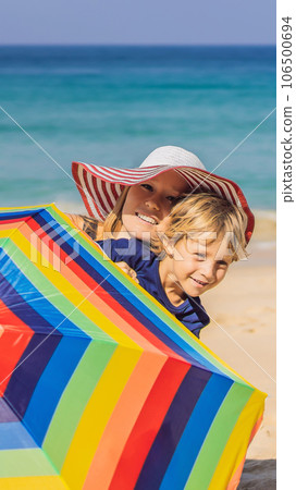 Mother and son on the beach in a hat and beach umbrella VERTICAL FORMAT for Instagram mobile story or stories size. Mobile wallpaper Mother and son on the beach in a hat and beach umbrella VERTICAL FORMAT for Instagram mobile story or stories size. Mobile wallpaper 106500694