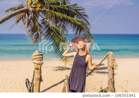 Vacation on tropical island. Woman in hat enjoying sea view from wooden bridge Vacation on tropical island. Woman in hat enjoying sea view from wooden bridge 106501841