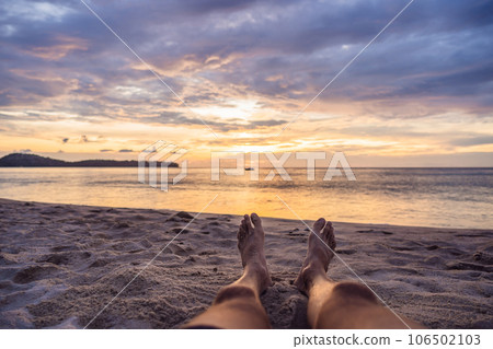 Close-up of female foot, Woman's feet walking to the sea in sunset colorful sky. Vacation, traveling and freedom concept.- Vintage tone 106502103