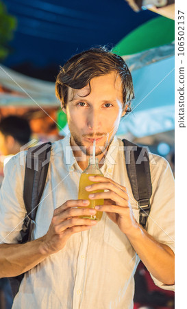 Man drinking sugar cane juice on the Asian market VERTICAL FORMAT for Instagram mobile story or stories size. Mobile wallpaper Man drinking sugar cane juice on the Asian market VERTICAL FORMAT for Instagram mobile story or stories size. Mobile wallpaper 106502137