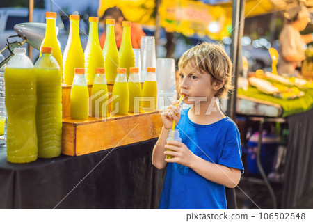 Boy drinking sugar cane juice on the Asian market 106502848