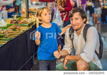 Dad and son are tourists on Walking street Asian food market 106502945
